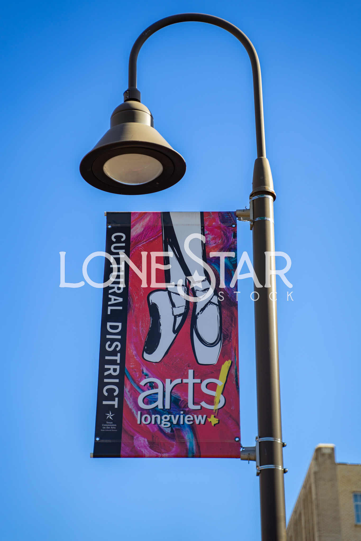 Preview of Longview's Cultural District Arts Street Banner with Image of Pointe Shoes on Street Lamp with Clear Blue Sky in Background